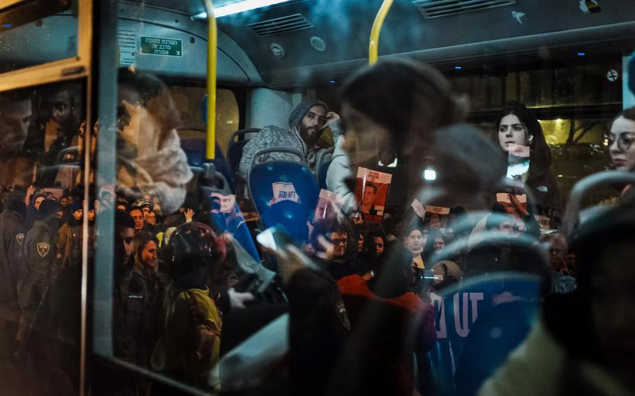 Commuters on a bus in downtown Jerusalem on Wednesday watch as their vehicle is held up in traffic congestion caused by protesters raising awareness for hostages who are still trapped in Gaza.