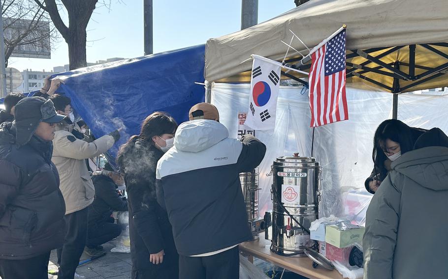 American and South Korean flags hang from a tent.