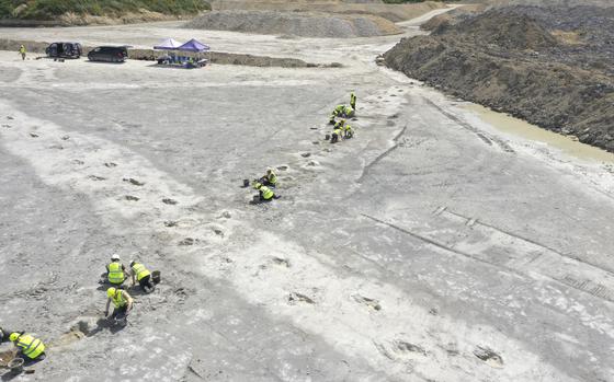 In this undated photo provided by the University of Birmingham on Thursday, Jan. 2, 2025, work underway as five extensive trackways that formed part of a “dinosaur highway” are uncovered, at Dewars Farm Quarry in Oxfordshire, England. (University of Birmingham via AP)