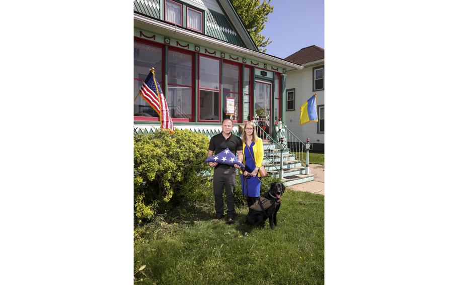 John and Heather Peters pose with Pepper, their son’s service dog.