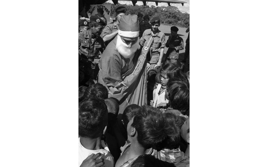 Santa Claus hands out presents to children, dependents of South Vietnamese Special Forces soldiers stationed at Nhon Cho.