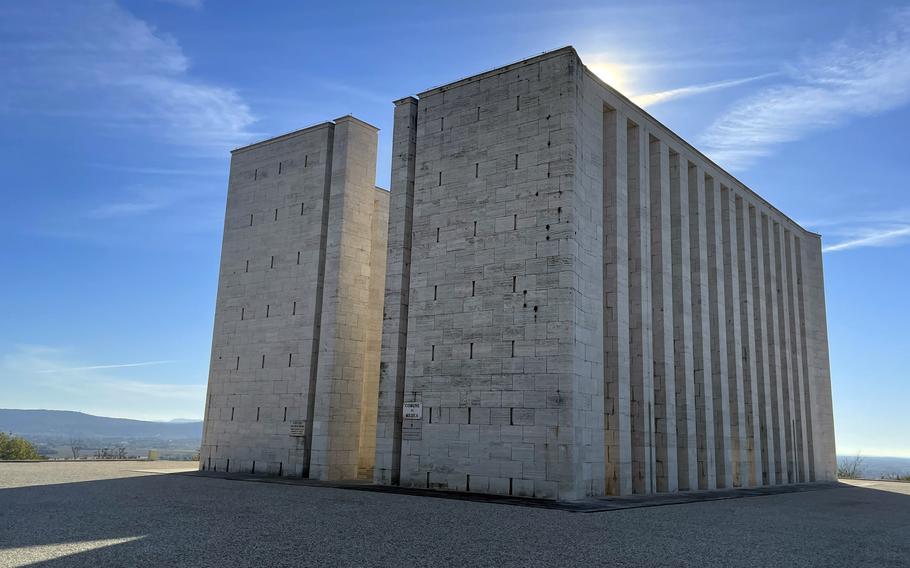 Stone columns of the peace monument rise into a blue sky.