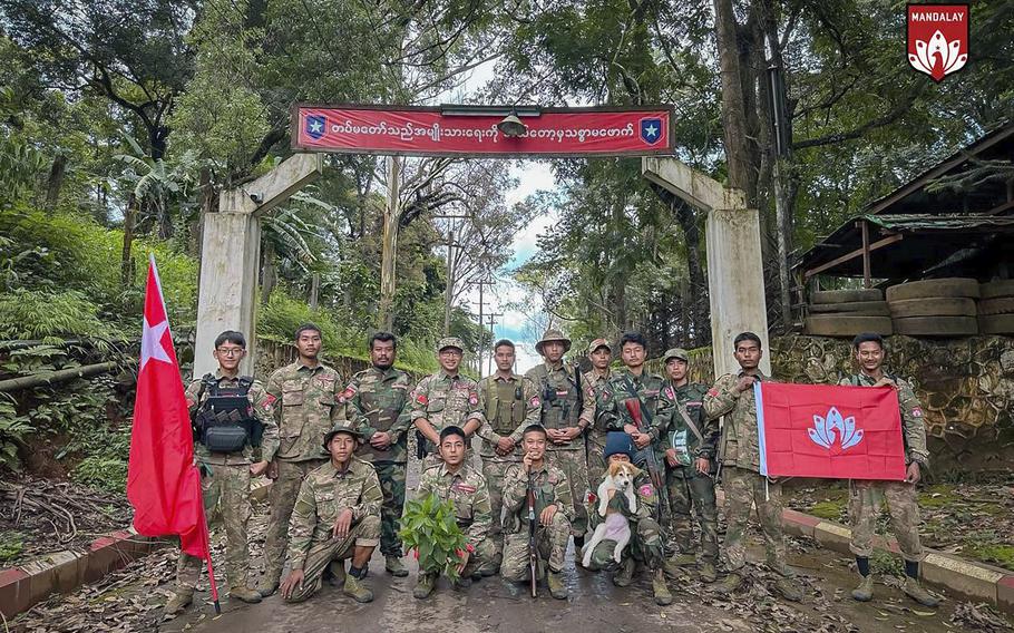 In this photo provided by Mandalay People’s Defence Force, its members pose for a photograph in front of the gate of the captured army battalion in Mogok township in Mandalay region, Myanmar, on July 25, 2024.