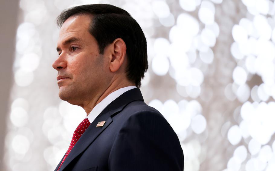 A side view of Marco Rubio, wearing a dark suit and seen from the shoulders up.