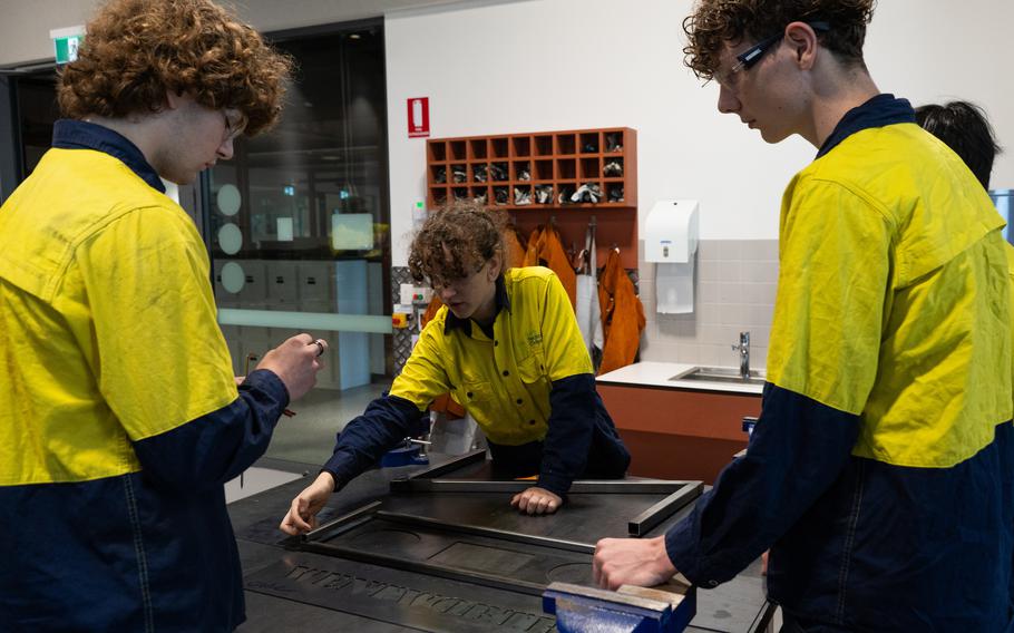 Students work together in the metal shop.