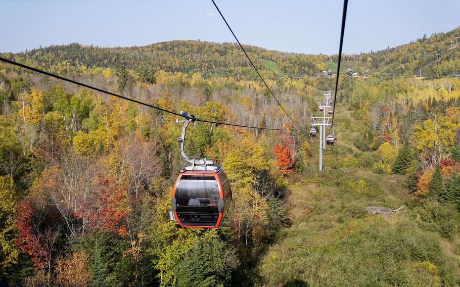 Visitors view fall colors on the Sawtooth Mountains while riding the Summit Express Gondola in Lutsen, Minn., on Oct. 3, 2023. The gondola, located at the Lutsen Mountains ski resort, is used by downhill skiers in the winter but welcomes leaf-peepers in the fall. 