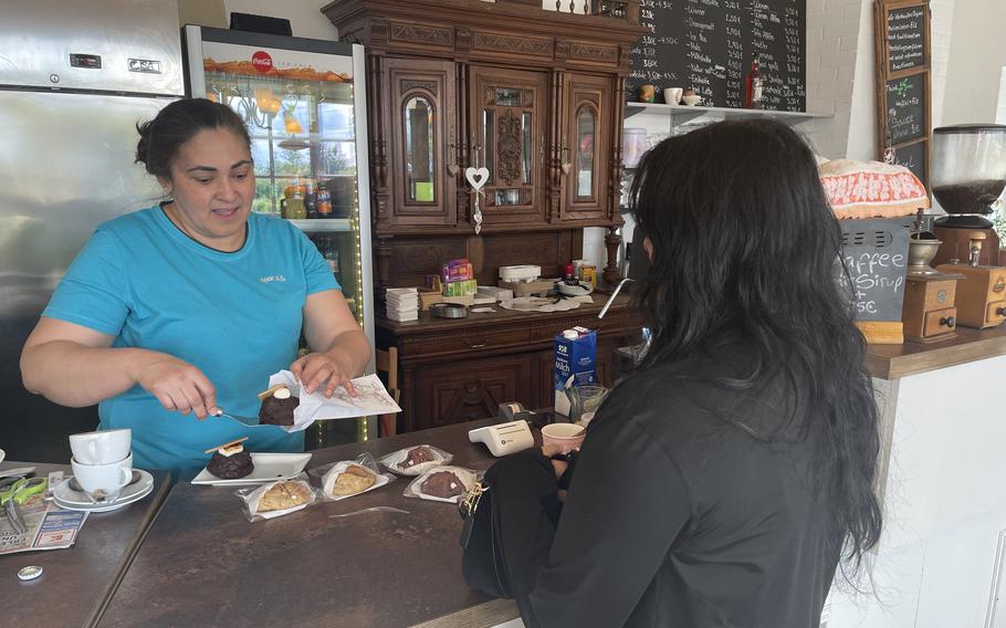 Yna Dan Navarro, the owner and main chef at the Corner Cafe in Otterbach, Germany, packages her homemade cookies for a customer on June 12, 2024.