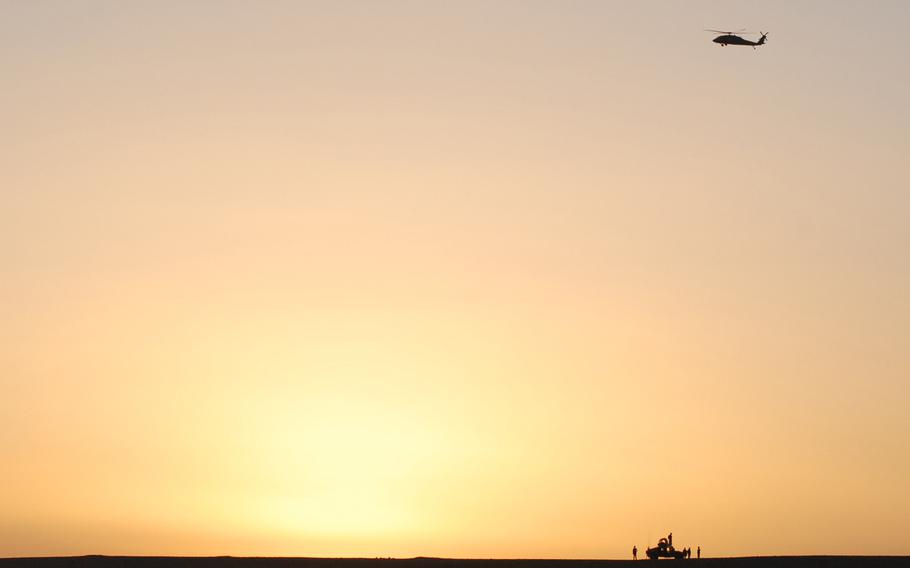 A Black Hawk circles around an Iraqi army Humvee