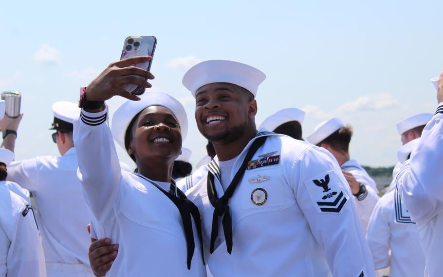 Two sailors grin as they take a selfie together.