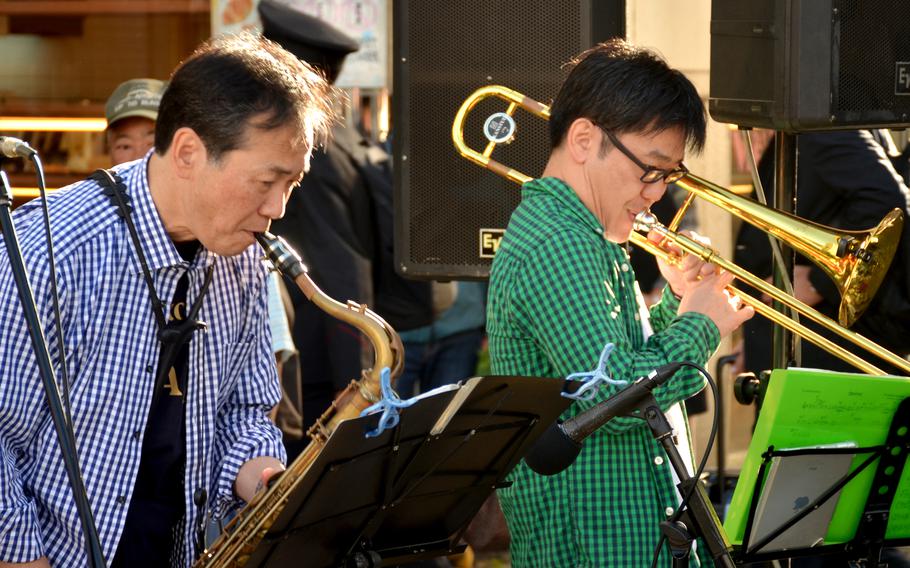 Japanese jazz musicians perform on a street during an outdoor festival.