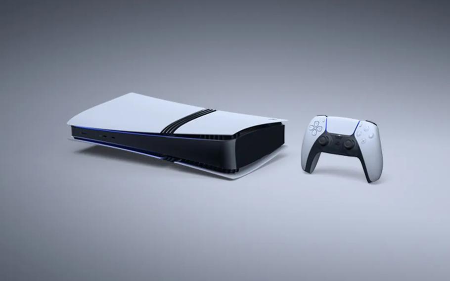 A black and white video game console and controller sit on a white table.