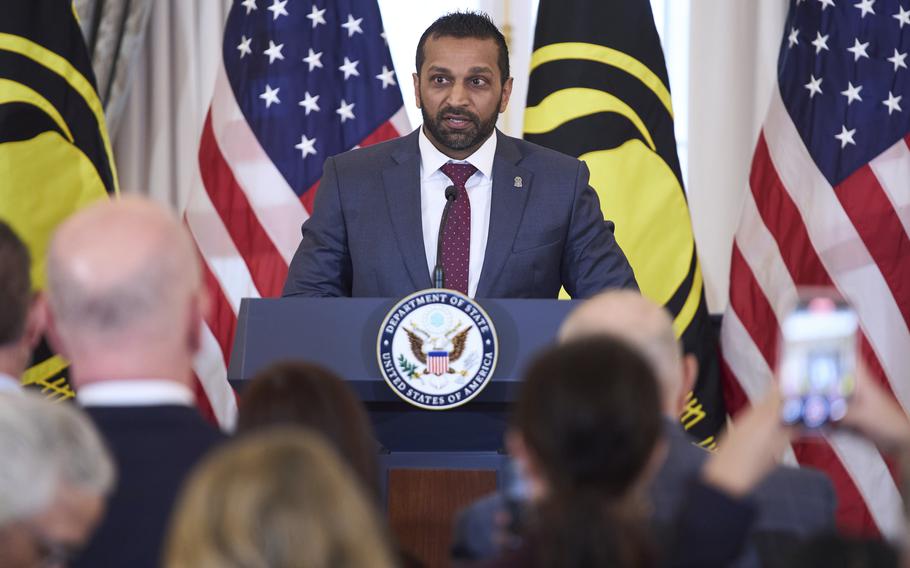 The FBI director at a lectern, with the FBI seal in front and U.S. flags behind.