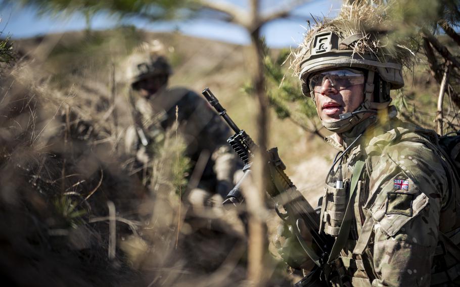 Cadets in camo take cover in a trench