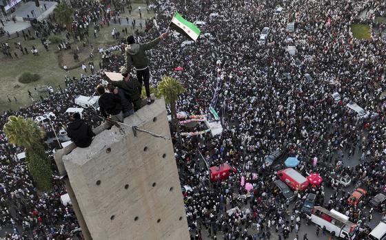 Masses of crowds throng in the streets of Damascus in this aerial shot.