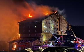 Firefighters work to extinguish a fire in a hotel at a ski resort of Kartalkaya in Bolu province, in northwest Turkey, Tuesday, Jan. 21, 2025. (IHA via AP)