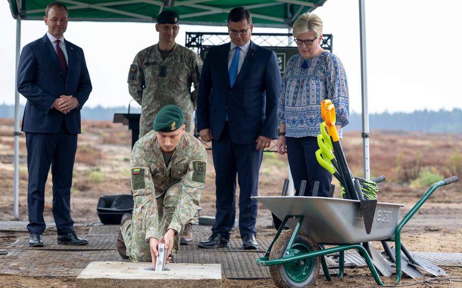 A Lithuanian service member buries a time capsule Aug. 19, 2024, at a site in Rudninkai, Lithuania, where a military base is being built to house a German combat brigade.