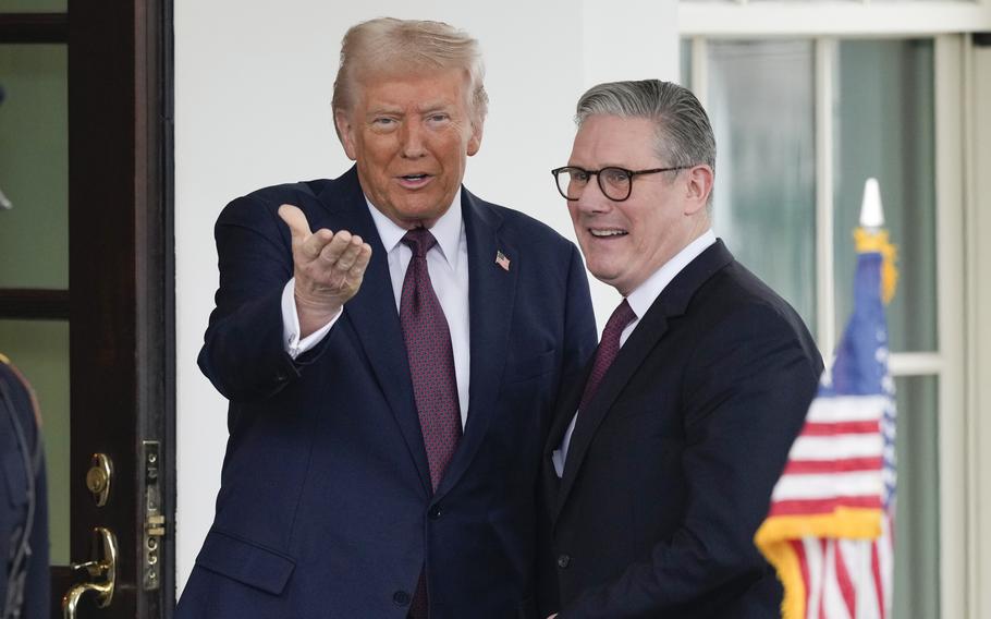 Donald Trump gestures with his hand as he greets Keir Starmer outside the White House.