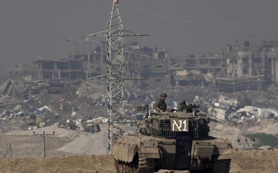 FILE - Israeli soldiers overlook the Gaza Strip from a tank, as seen from southern Israel, on Friday, Jan. 19, 2024. (AP Photo/Maya Alleruzzo, File)