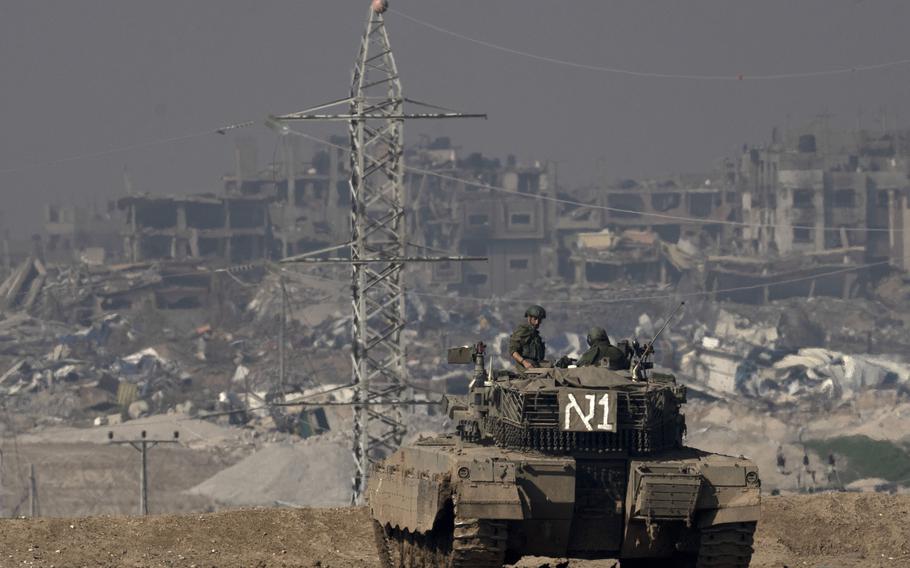 Israeli soldiers overlook the Gaza Strip from a tank