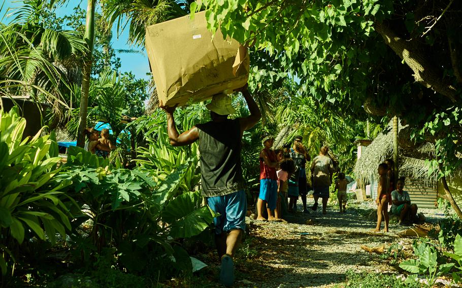 A villager from Fais carries an empty carboard box back to his house. The box was full of humanitarian supplies and Christmas presents before being emptied by the village chief to sort and distribute equally. Even the used box and nylon straps are offered by the chief to the other men of the village. 