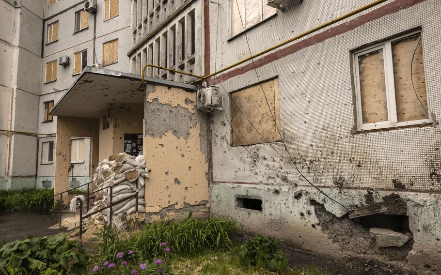 Boarded-up windows and sandbags protect the entrance to a residential building in Kharkiv’s Saltivskyi district.