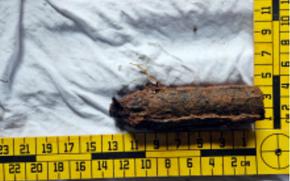 A piece of U.S. military ordnance left over from World War II is measured.