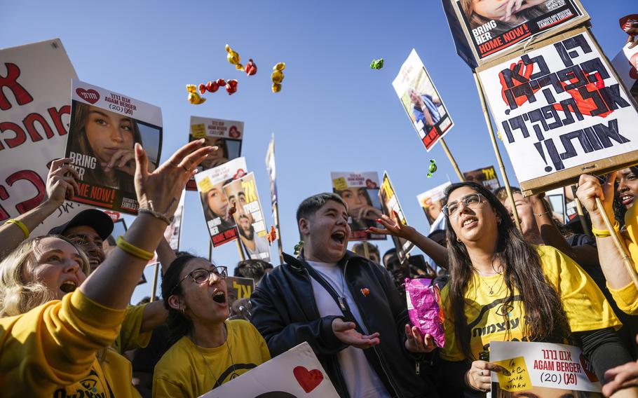 People wearing yellow shirts and holding signs celebrate.