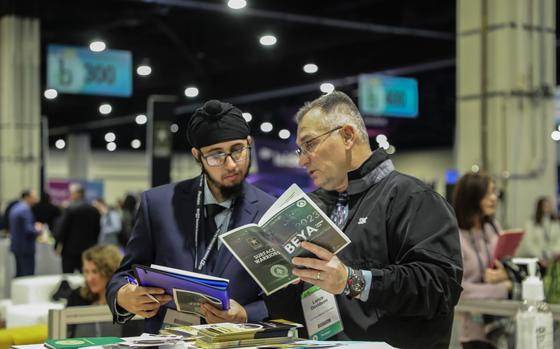 Two men talking and holding pamphlets