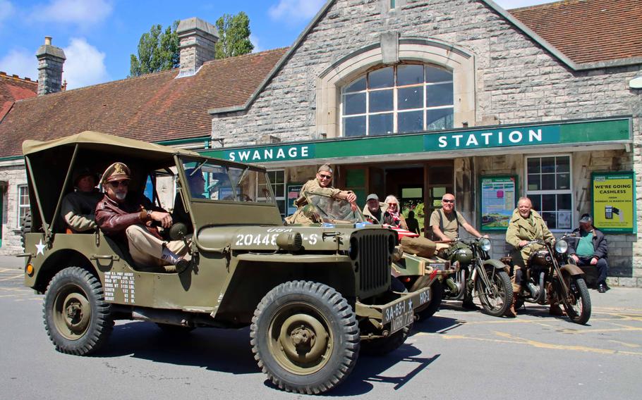 People in World War II military attire attend a plaque unveiling ceremony in Swanage, England, on May 27, 2024. The plaque commemorates American soldiers assigned to the 1st Infantry Division’s 26th Infantry Regiment who lived and trained in the town prior to D-Day.