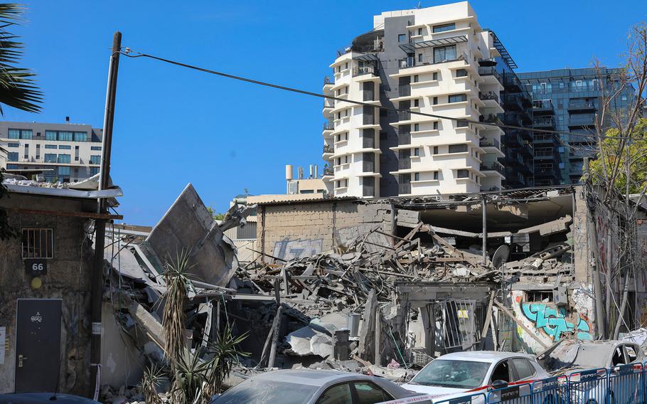 A building that collapsed due to the fall of a rocket, and destroyed and dusty cars in south Tel Aviv, Sunday, Oct. 8, 2023.