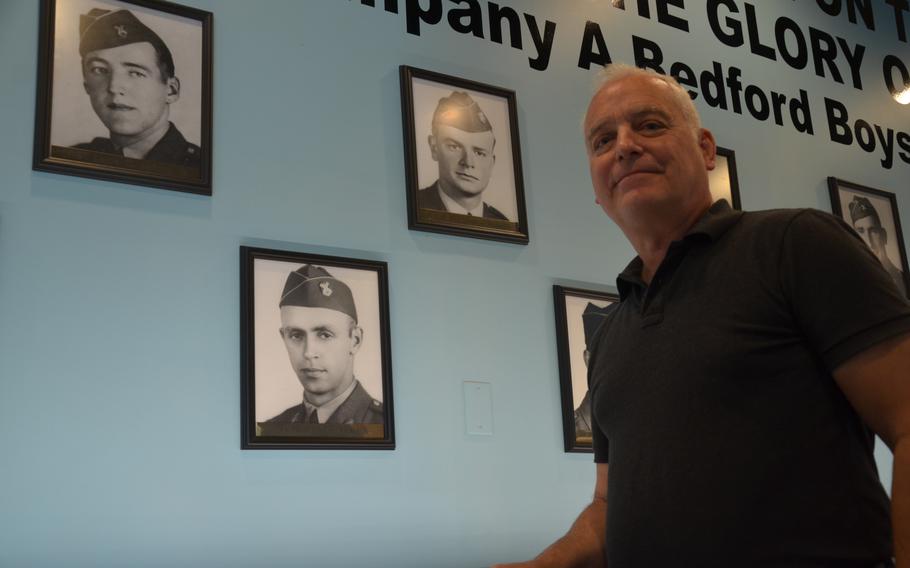 John Boggess standing next to photos of his uncles on the left, Bedford and Raymond Hoback, at the Bedford Boys Tribute Center on May 10, 2024. Raymond and Bedford were two of the 20 soldiers from the community of Bedford, Va., who died on or shortly after D-Day as part of Company A of the 116th Infantry Regiment, 29th Division. 