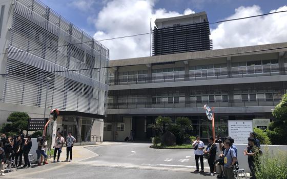Members of the Japanese media wait outside the Naha District Court July 12, 2024, before the start of  hearing on charges a U.S. Air Force member kidnapped and sexually assaulted a minor.
