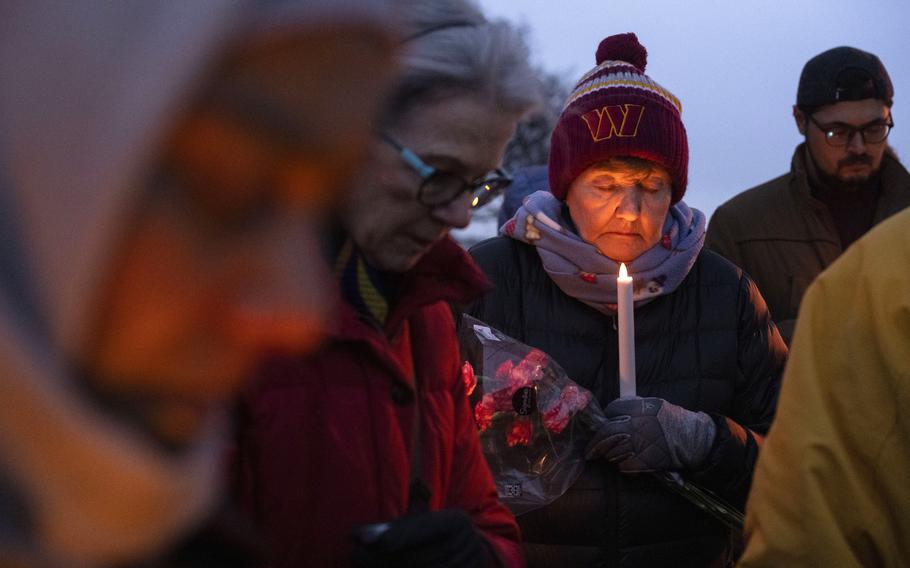 Sandy Woods closes her eyes for prayer during a candlelight vigil, Wednesday, Feb. 5, 2025 in Alexandria, Va., for the victims of the mid-air collision of an American Airlines jet and a Black Hawk helicopter at Reagan National Airport. 