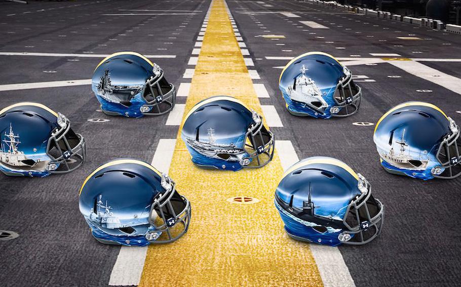 Navy helmets on a runway. The images on the helmets show ships and subs at sea.