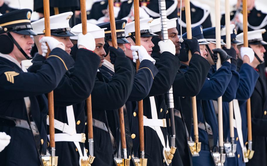 A line of members of a color guard hold their flags.