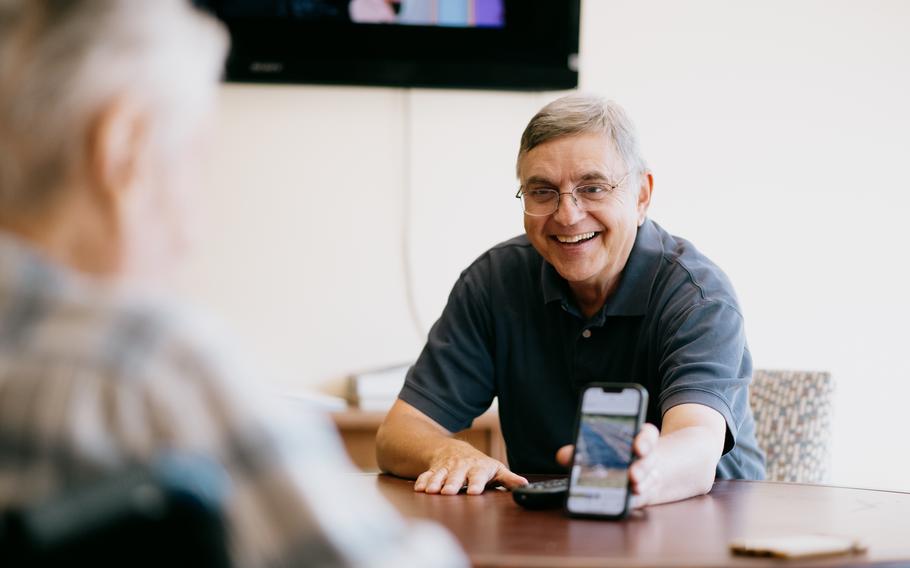 West Virginia University Professor Emeritus Mark Double holds out his phone so that retired WVU plant pathology professor Mannon Gallegly, 101, can see pictures of the tomato plants that were planted that morning at the WVU Organic Farm in Morgantown, W.Va.