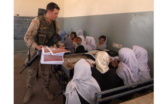 Jagadan, Afghanistan, Apr. 11, 2005: Spc. Lee Isham of the 4th Psychological Operations Group hands out copies of the Peace newspaper to pupils in an all-girls' class at the Jagadan village school, just outside the gates of Bagram Air Base, Afghanistan. 
Isham and Sgt. Larry Carson also brought backpacks, clothes, shoes and radios to the school, and asked the principal what else he could use. About 700 children, taught by 28 teachers, go to the school in morning and afternoon sessions. 

META TAGS: Operation Enduring Freedom, War on Terror, Afghanistan, Afghan, children; eductation; 