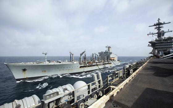 The fleet replenishment oiler USNS Big Horn sails alongside the aircraft carrier USS Abraham Lincoln on Sept. 11, 2024, during a replenishment-at-sea in U.S. Central Command's area of responsibility. Big Horn ran aground in Middle East waters Sept. 23, the Navy said.