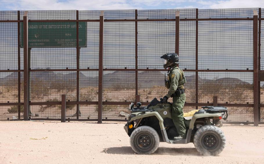 A Border Patrol agent watched a section of the wall at the border with Mexico in Sunland Park, N.M., on June 23, 2021.
