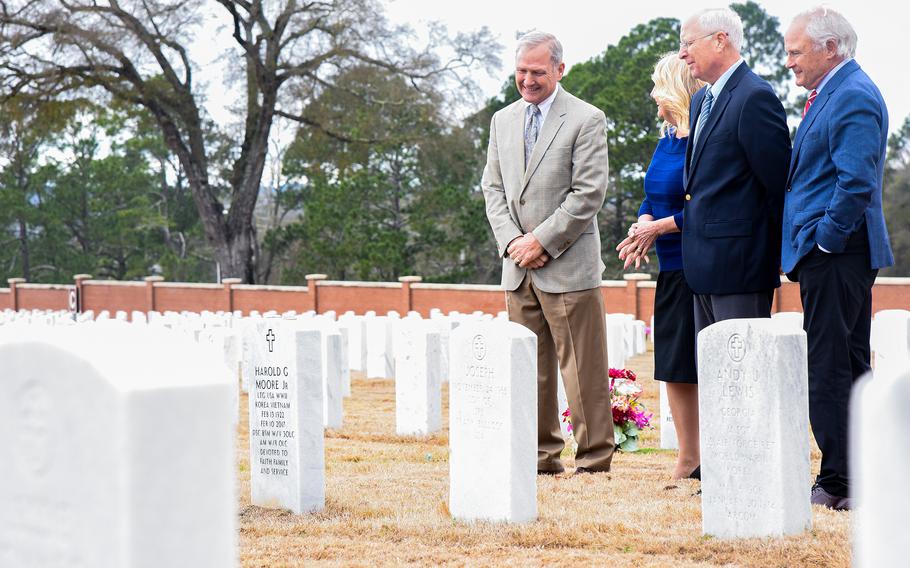 Four people standing in a cemetery.