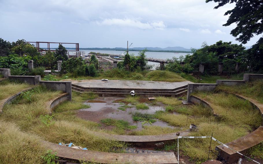 Concrete slabs in the apparent shape of an amphitheater overgrown with grass.