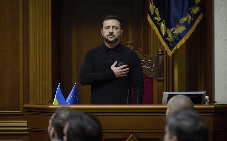 Ukraine President Volodymyr Zelenskyy places his hand over his heart as he listens to the national anthem.