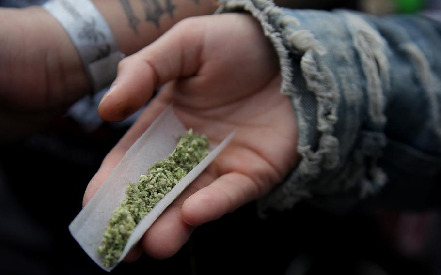 A person prepares a marijuana cigarette during 420 celebrations at Washington Square Park in New York City on April 20, 2024. 