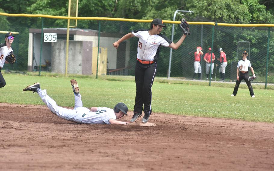 Naples' Matthew Hostetler slides back into second base as a pickoff throw goes over the head of Spangdahlem's Cohen Mendiola at the DODEA European Division II/III championship game at Ramstein Air Base, Germany.