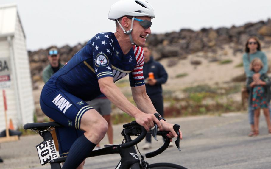 Navy Lt. Cmdr. Kyle Hooker rides to victory during the 2024 Armed Forces Triathlon Championships at Point Mugu Beach, Calif. Service members from the Army, Marine Corps, Navy (with Coast Guard) and Air Force (with Space Force) competed alongside Canadian forces for gold. 