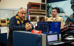 President Biden’s Navy secretary rests his hands on a table in a U.S. Marine Corps recruiting office.