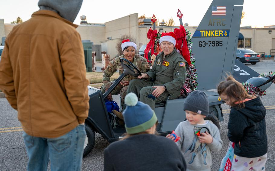 Col. Matthew Ghormley, 507th Air Refueling Wing commander, and Master Sgt. Dontia Yates, the 507th ARW first sergeant, drive the wing’s “StratoCart” and pass candy to children