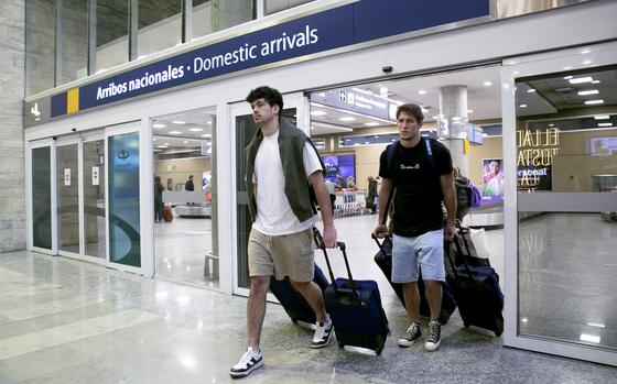 French rugby players Oscar Jegou, right, and Hugo Auradou arrive from Mendoza at the airport in Buenos Aires, Argentina, Tuesday, Aug. 27, 2024. The players were arrested following charges of sexual assault after France played Argentina in Mendoza on July 6. (AP Photo/Virginia Chaile)