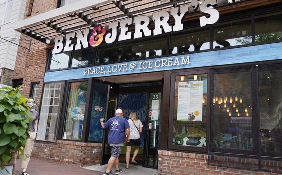 The front of a Ben & Jerry’s shop is seen in Burlington, Vt., with two people walking in.