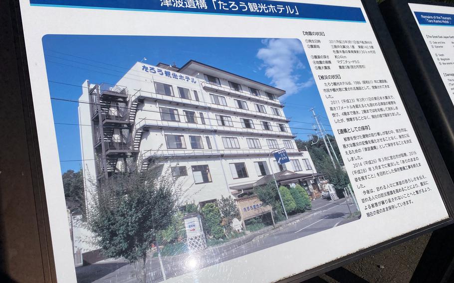 A sign displays Japanese writing and a photo of a multi-story hotel.